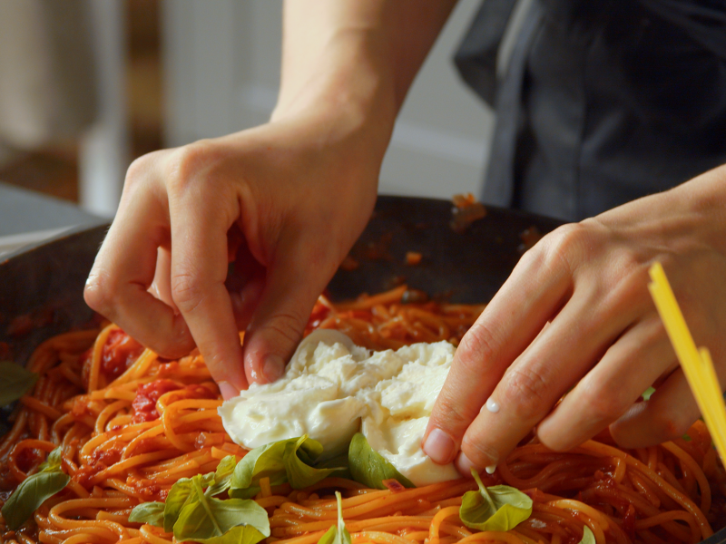 Sartén con espaguetis en una olla con burrata